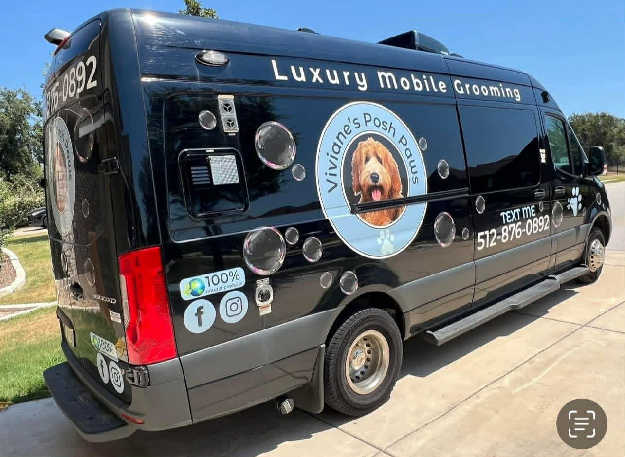 The black Viviane's Posh Paws luxury mobile grooming van parked on a residential street